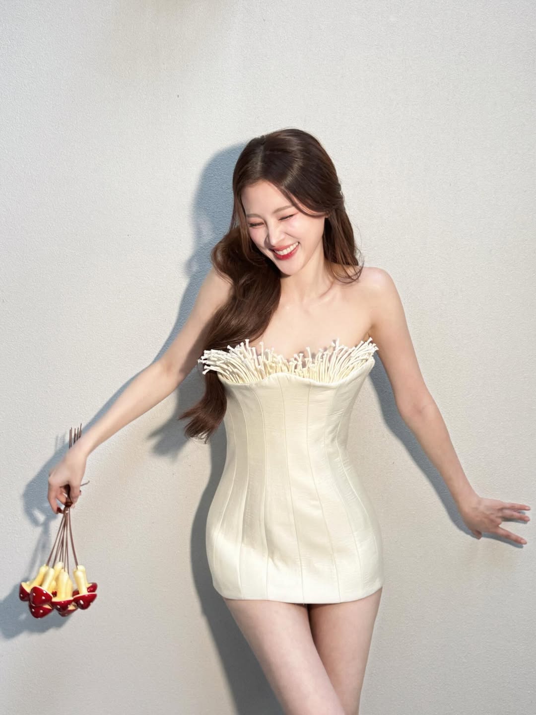 Một chiếc đầm ngắn dáng ôm với thiết kế cúp ngực giúp Baifern khoe trọn bờ vai và vóc dáng mảnh mai. Outfit mang đến vẻ ngoài vừa gợi cảm vừa ngọt ngào nhờ gam màu kem nhẹ nhàng cùng chi tiết tua rua độc đáo ở phần ngực, tổng thể trông nổi bật nhưng không hề sến súa