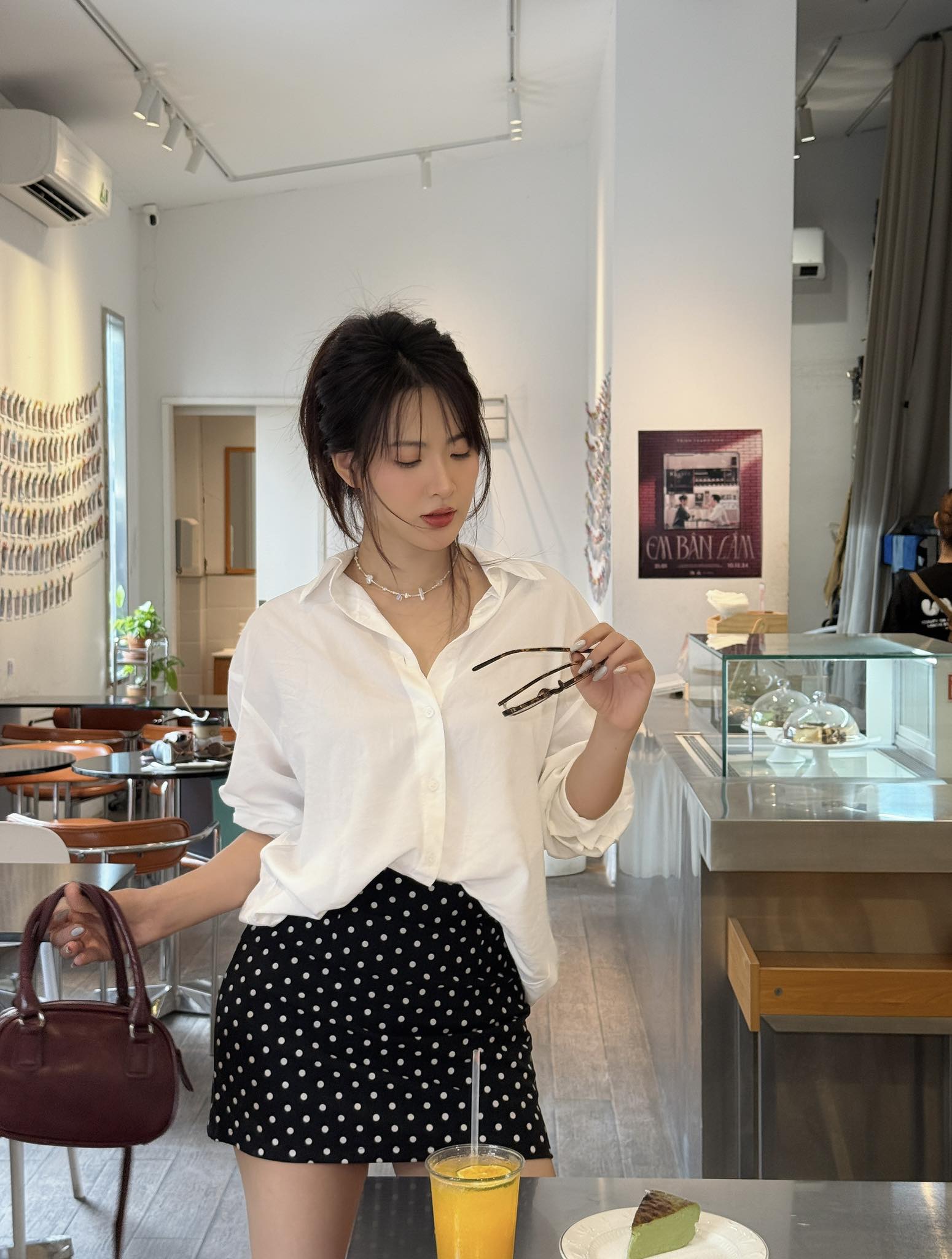 Diện chân váy chấm bi hot hit, Minh Trang chọn phối đơn giản cùng sơ mi trắng để tạo tổng thể thanh lịch mà vẫn nổi bật. Cách sơ vin gọn gàng giúp outfit trông chỉn chu, tôn dáng và mang đến vẻ ngoài slay hết nấc. Mùa hè năm nay, họa tiết chấm bi đang được nhiều tín đồ thời trang yêu thích, nàng nào chưa sở hữu thì nên tranh thủ sắm liền 1 item