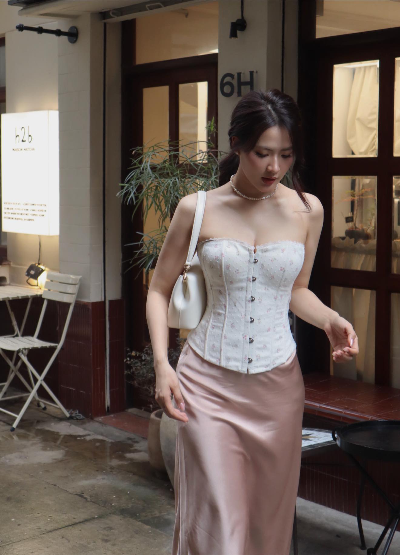 Áo cúp ngực và chân váy lụa là “cặp bài trùng” giúp Minh Trang khoe trọn vẻ ngoài nữ tính và cuốn hút. Chất liệu mềm mại cùng phom dáng ôm nhẹ không chỉ tôn visual mà còn giúp vóc dáng thêm thanh thoát, nổi bật. Cô cũng khéo léo điểm xuyết thêm phụ kiện như vòng cổ tròn để tổng thể trông tinh tế và có điểm nhấn hơn