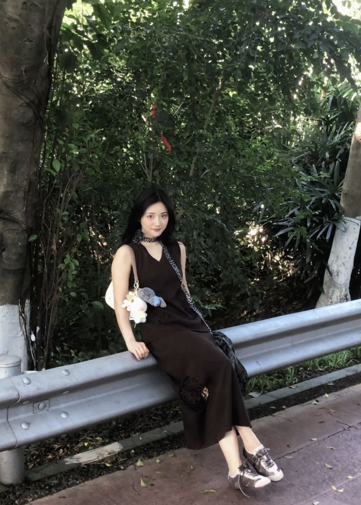 Diện nguyên set tông nâu trung tính gồm áo cổ V và chân váy dài, Thẩm Nguyệt mang đến cảm giác nhẹ nhàng, thanh lịch nhưng vẫn trẻ trung. Cô hoàn thiện outfit với đôi sneaker cùng tông để tổng thể thêm phần hài hòa. Điểm nhấn thú vị nằm ở chiếc khăn mảnh chấm bi được quàng hờ ở cổ, giúp set đồ mềm mại và có cảm giác bay bổng hơn
