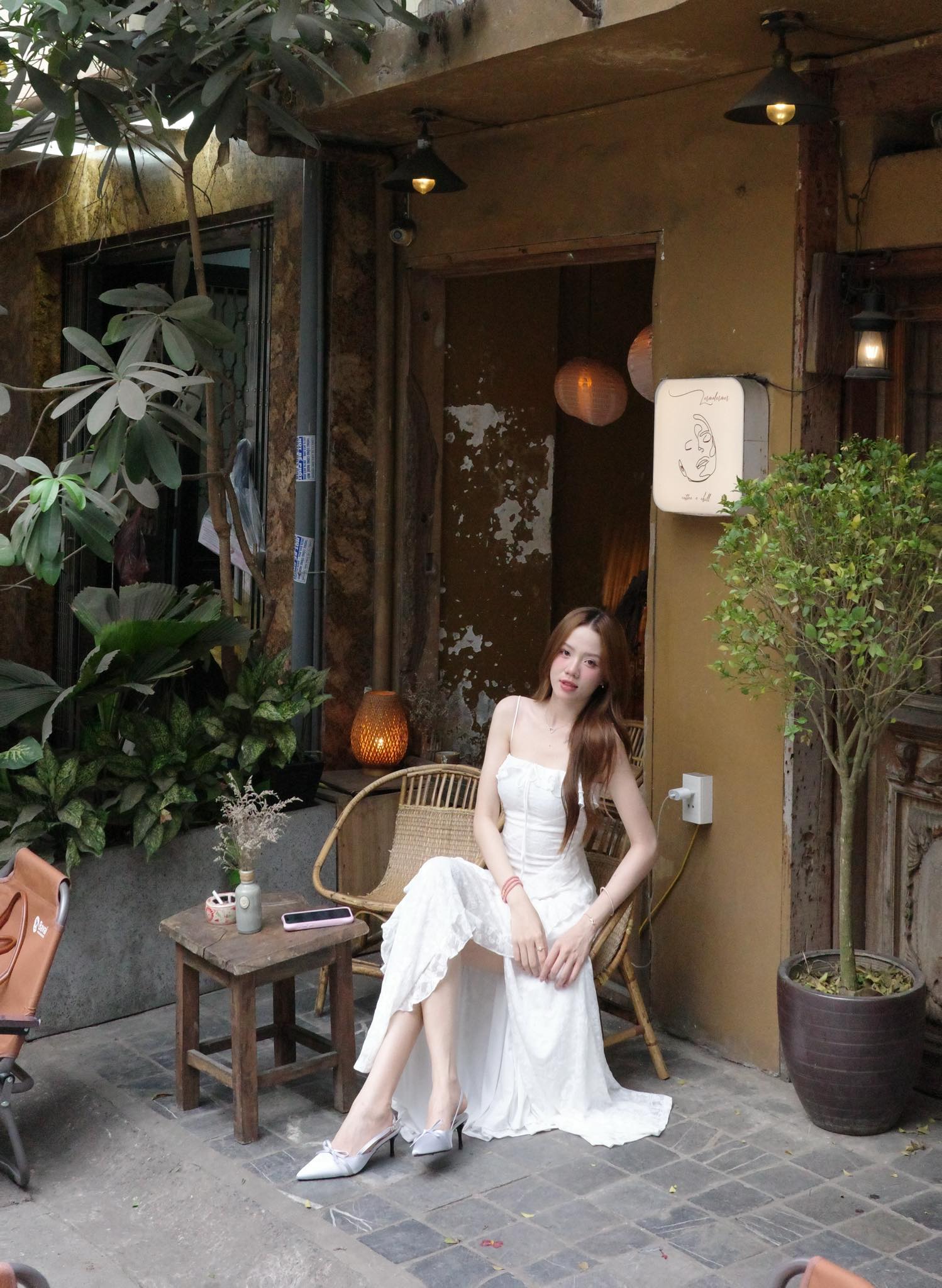 Mèo Trái Đất gây ấn tượng với phong cách thời trang trẻ trung, hiện đại nhưng vẫn mang nét nữ tính dịu dàng. Cô lựa chọn mẫu váy hai dây dáng dài tông trắng thanh lịch, nổi bật nhờ phần xẻ tà tinh tế giúp tổng thể thêm mềm mại và cuốn hút. Thiết kế ôm nhẹ cơ thể kết hợp cùng giày cao gót mũi nhọn càng tôn lên vóc dáng thanh thoát, tạo cảm giác sang chảnh mà không quá cầu kỳ