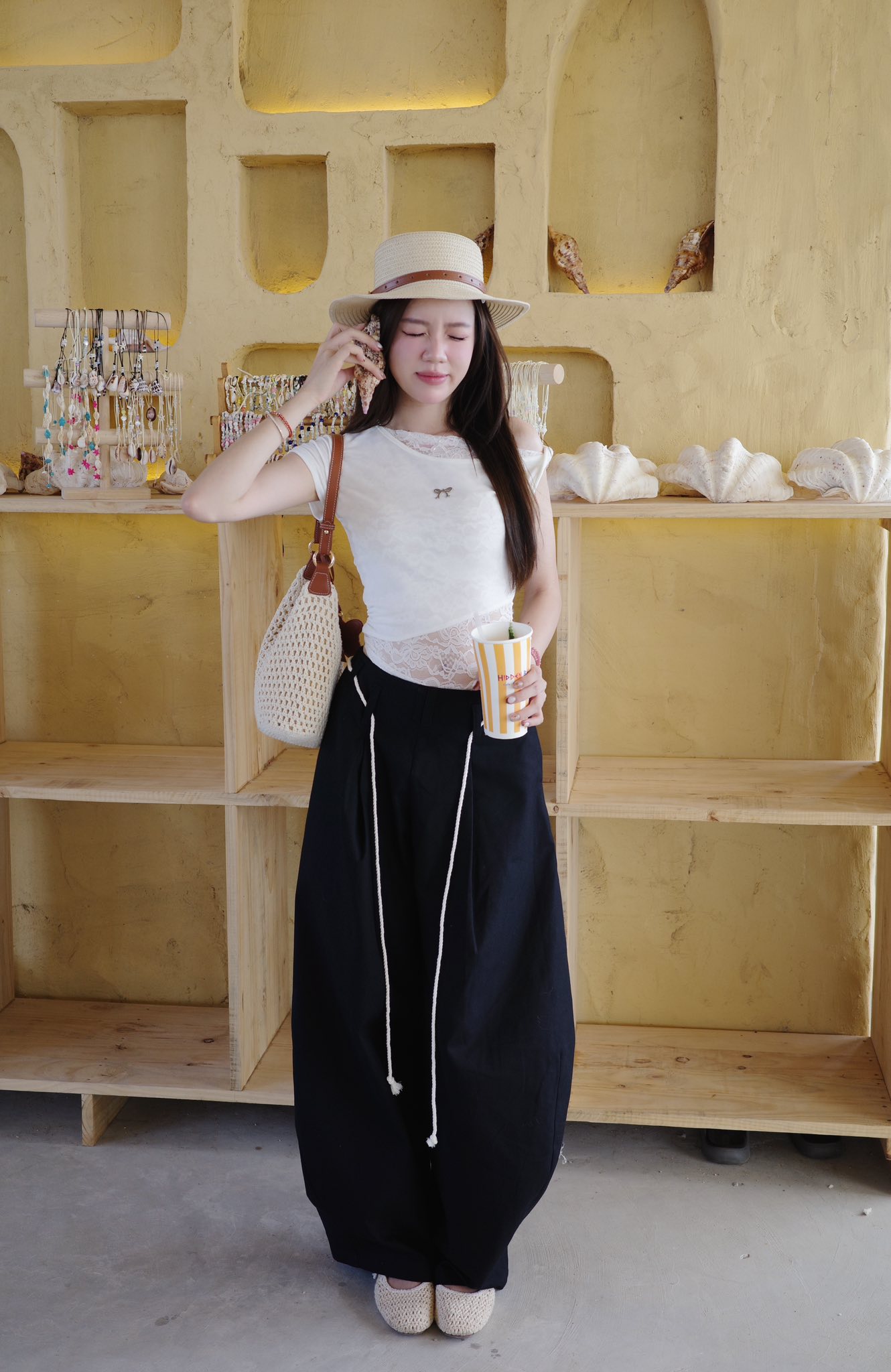 Ở tuổi 27, Mèo Trái Đất vẫn ghi điểm với style trẻ trung và ngọt ngào. Cô chọn diện áo lệch vai phối cùng quần ống cong tạo hiệu ứng trên ôm - dưới rộng, giúp tổng thể trông cao ráo và tôn dáng hơn. Các phụ kiện như túi đan và mũ cói góp phần tạo điểm nhấn cho outfit đậm vibe hè, diện đi chơi hay đi biển là quá ư hợp lý