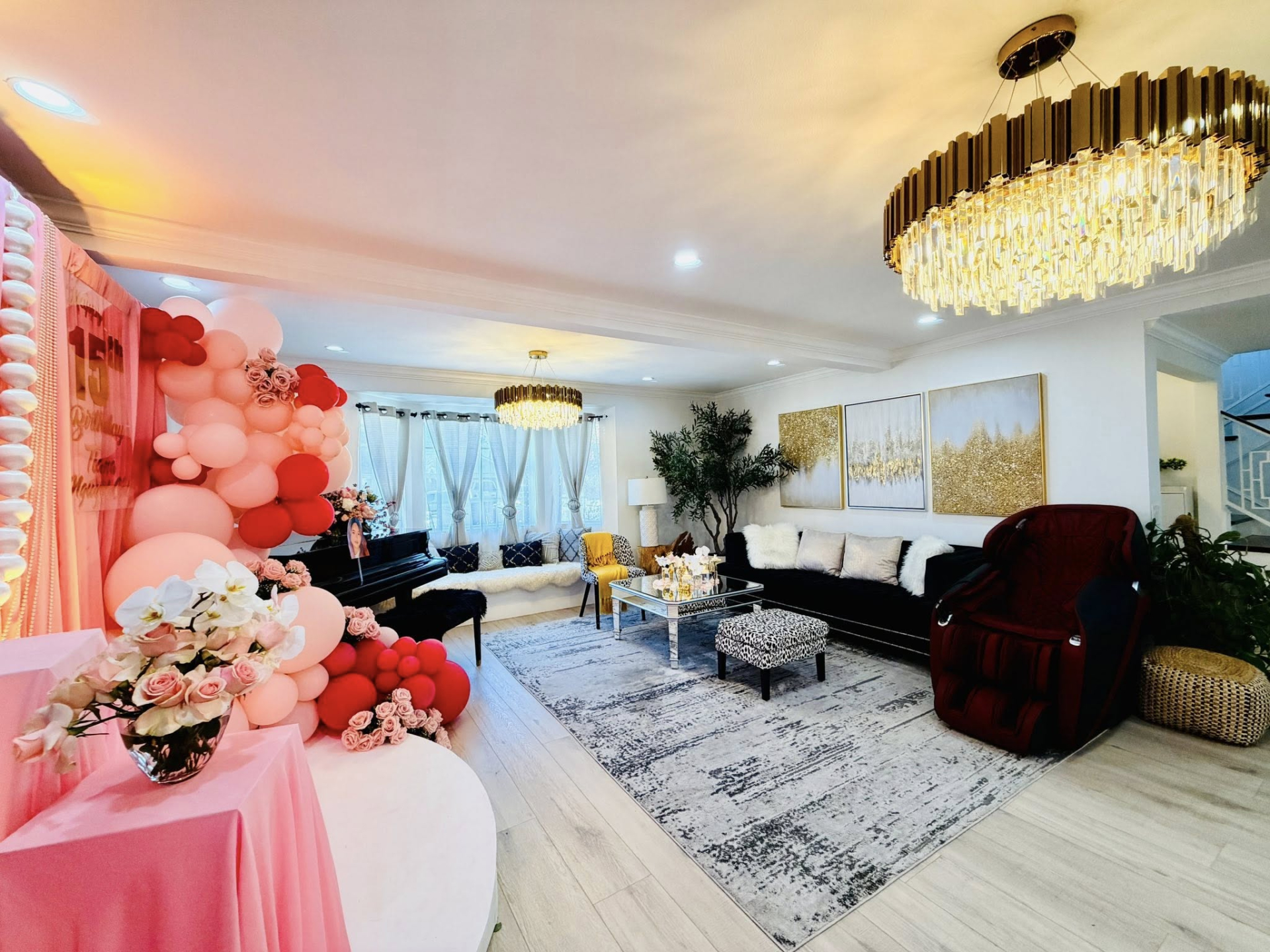 Khu vực phòng khách nổi bật với hệ đèn chùm, sofa dài, ghế massage và tranh nghệ thuật