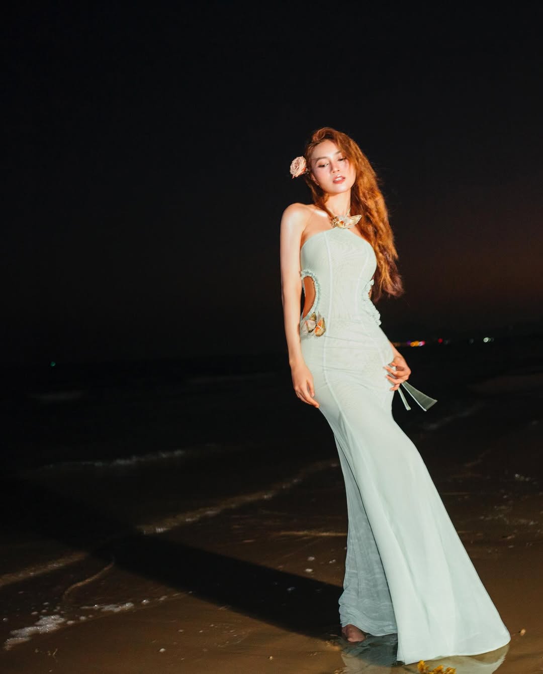 Chán đồ bơi, người đẹp khoe sắc vóc nuột nà trong bộ váy dáng dài mang tông màu xanh bạc hà dịu mát. Thiết kế cổ yếm kết hợp cùng chi tiết cut-out ở vòng eo giúp tôn trọn vẹn đường cong gợi cảm của nữ diễn viên. Outfit này cũng là gợi ý hoàn hảo cho chị em hẹn hò tiệc tối lãng mạn hoặc muốn có 1.000 bức ảnh