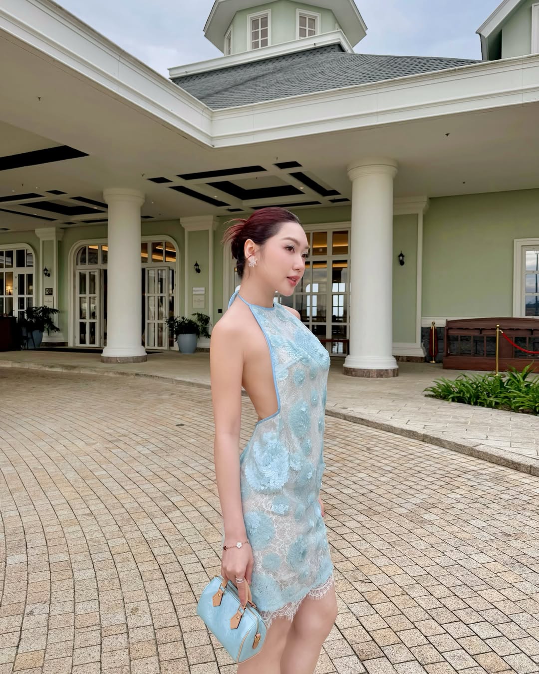 Chloe Nguyễn hóa thân thành nàng tiên cá hiện đại trong chiếc đầm yếm sắc xanh pastel dịu mát, ăn điểm nhờ kỹ thuật đính kết hoa nổi phủ trên nền vải ren xuyên thấu kết hợp cùng chi tiết hở lưng trần táo bạo tôn vóc dáng mảnh mai của cô nàng. Chiếc váy từ Valenciani giúp nàng tiểu thư toát lên vẻ phóng khoáng, thời thượng mà còn giữ trọn nét thanh lịch, kiêu sa chuẩn khí chất công chúa.