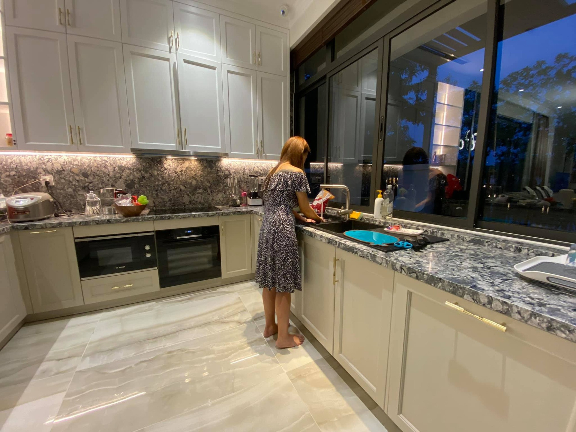 Góc bếp được bố trí hướng ra sân vườn phía sau, tận dụng ánh sáng tự nhiên và khoảng xanh bên ngoài