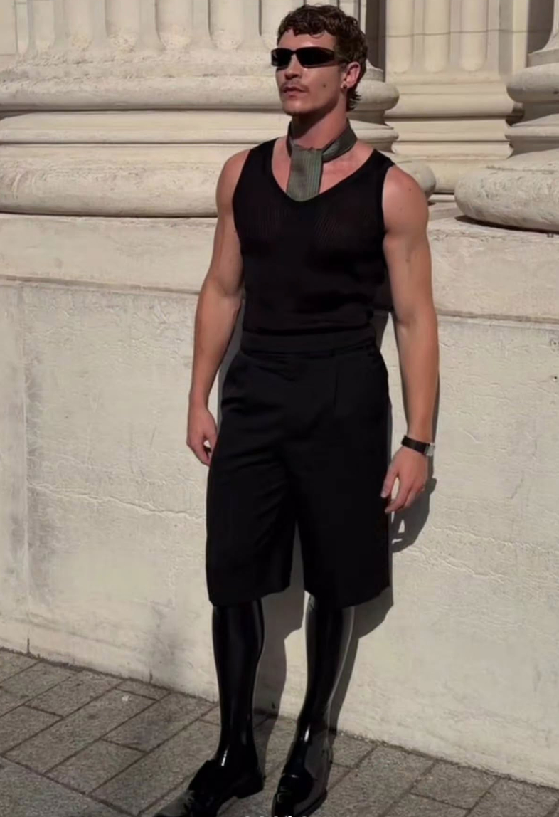  Ngay sau đó, nam diễn viên đã cởi bỏ lớp áo khoác ngoài. Bên trong anh diện áo tank top cùng quần âu dáng short đen. Điểm nhấn vẫn nằm ở đôi boot da latex cùng chiếc khăn lụa.