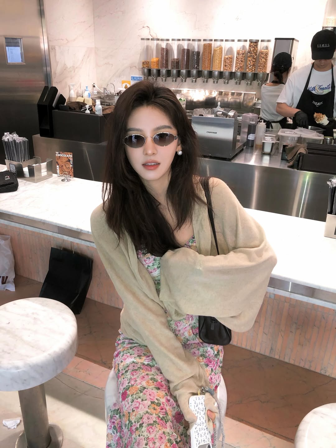 Ghé một quán cafe, Chương Nhược Nam đốn tim fan với giao diện chuẩn nàng thơ dịu dàng, cổ điển. Cô chọn một chiếc váy hai dây họa tiết hoa nhí mang sắc hồng xanh ngọt ngào, khoác hờ bên ngoài là chiếc áo cardigan mỏng màu be. Sự kết hợp này mang lại 