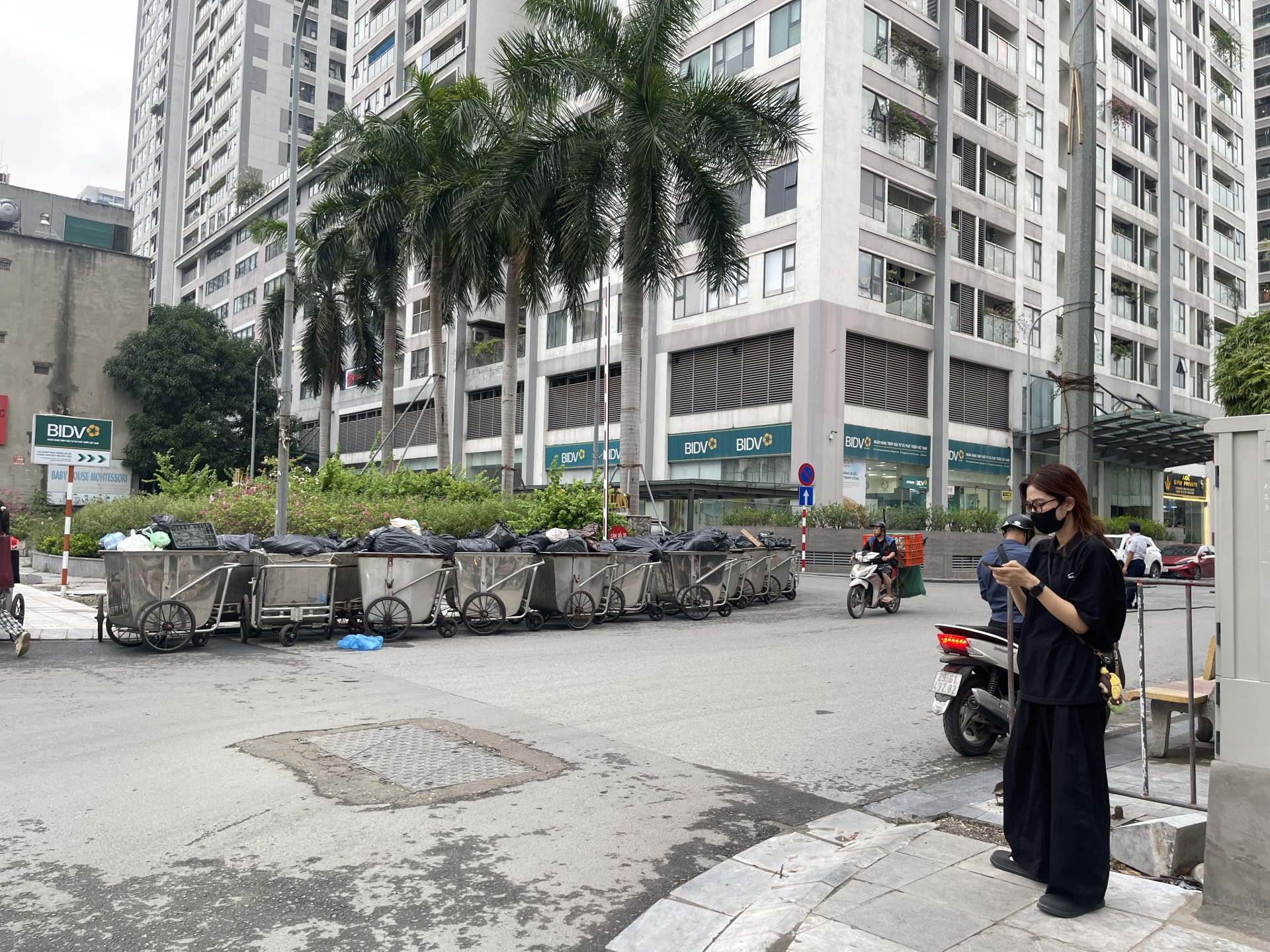 Bên ngoài sảnh chung cư, những xe rác cũng đầy chặt và chưa được chuyển đi