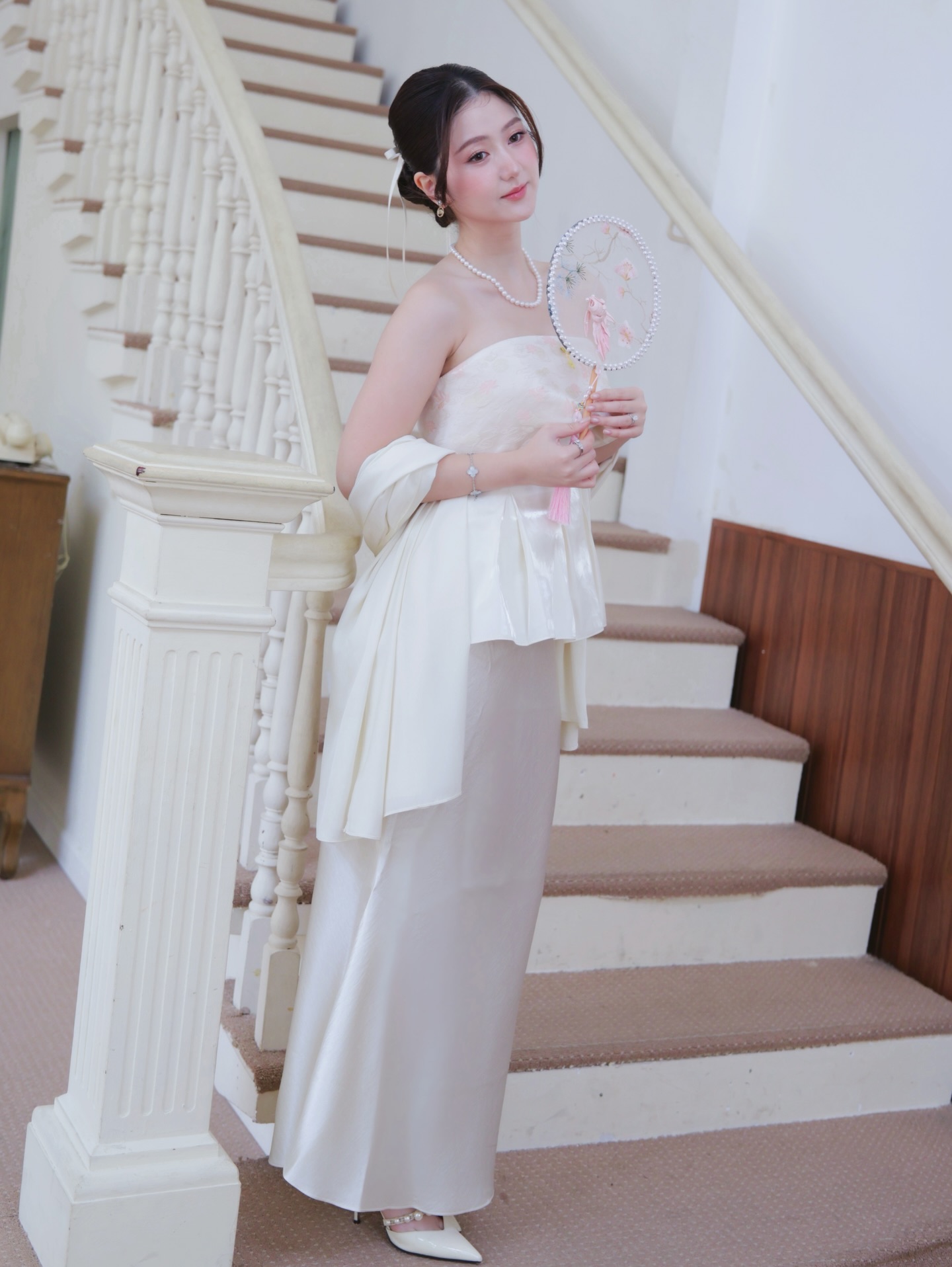 Cuối cùng là layout chuẩn nàng thơ đài các trong layout mang hơi hướng cổ điển. Outfit này giúp Hà My khoe vẻ đẹp thanh lịch, gồm áo quây cúp ngực mix với chân váy lụa tone màu trắng kem sang trọng. Việc khéo léo kết hợp thêm chiếc khăn choàng lụa giúp tổng thể layout toát lên vibe tiểu thư quyền quý, nhẹ nhàng và đầy cuốn hút.