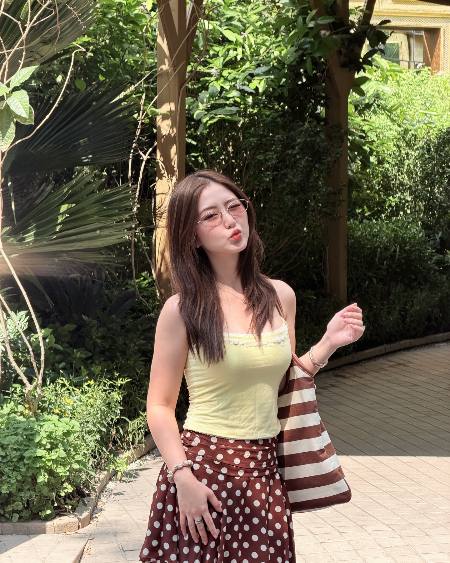Thả dáng dưới nắng hè, Hà My gây ấn tượng với outfit mát mẻ, tươi tắn. Nàng beauty blogger mix chiếc áo hai dây ôm sát tone vàng bơ cùng chân váy ngắn họa tiết chấm bi màu nâu hot trend. Thiết kế váy ngắn cạp cao ôm vòng eo không chỉ tôn lên vóc dáng thon gọn mà còn giúp cô nàng 1m55 ăn gian chiều cao, mang lại diện mạo năng động, ngọt ngào làm ai nhìn cũng thấy dễ chịu.