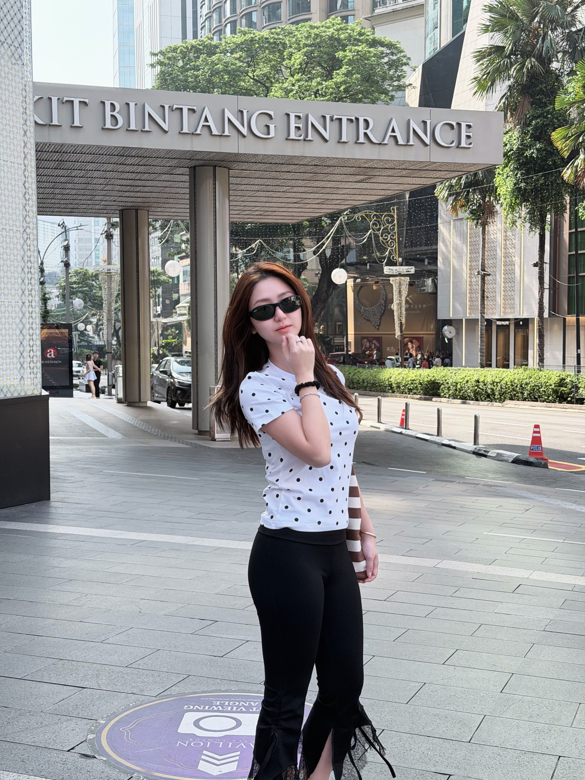 Khi xuống phố, Hà My khéo léo kết hợp chiếc áo chấm bi cùng quần dài ôm sát màu đen. Điểm nhấn của set đồ là chi tiết xẻ tà phối voan ren nhẹ nhàng ở gấu quần, giúp tạo hiệu ứng kéo dài đôi chân một cách tự nhiên cho cô nàng 1m55. Nhìn tổng thể, outfit này tuy đơn giản nhưng toát lên vibe một quý cô hiện đại, sành điệu và ngập tràn năng lượng.