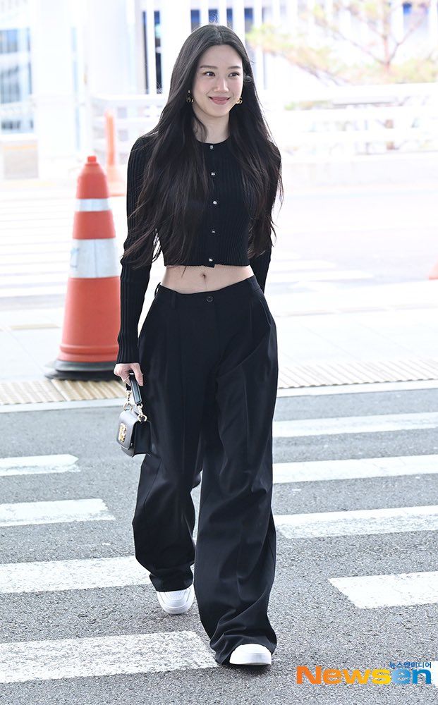 Không thể thiếu combo áo cardigan đen croptop và quần âu ống suông đồng màu. Cô hoàn thiện bằng sneaker trắng năng động và túi nhỏ cầm tay thanh lịch.