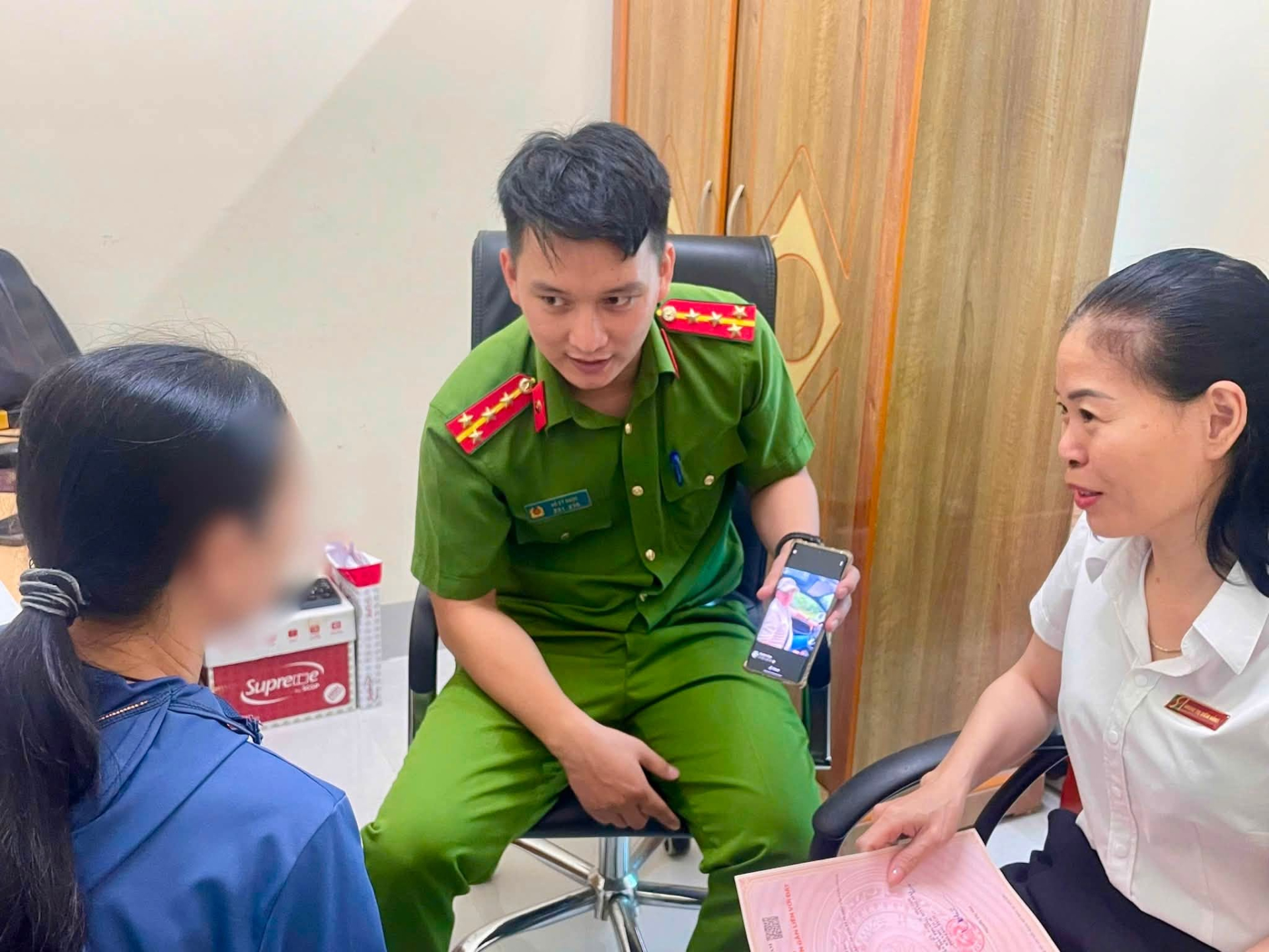 Lưc lượng công an phân tích phương thức, thủ đoạn lừa đảo trên không gian mạng cho người phụ nữ. (Ảnh: Công an phường Hoàng Mai).