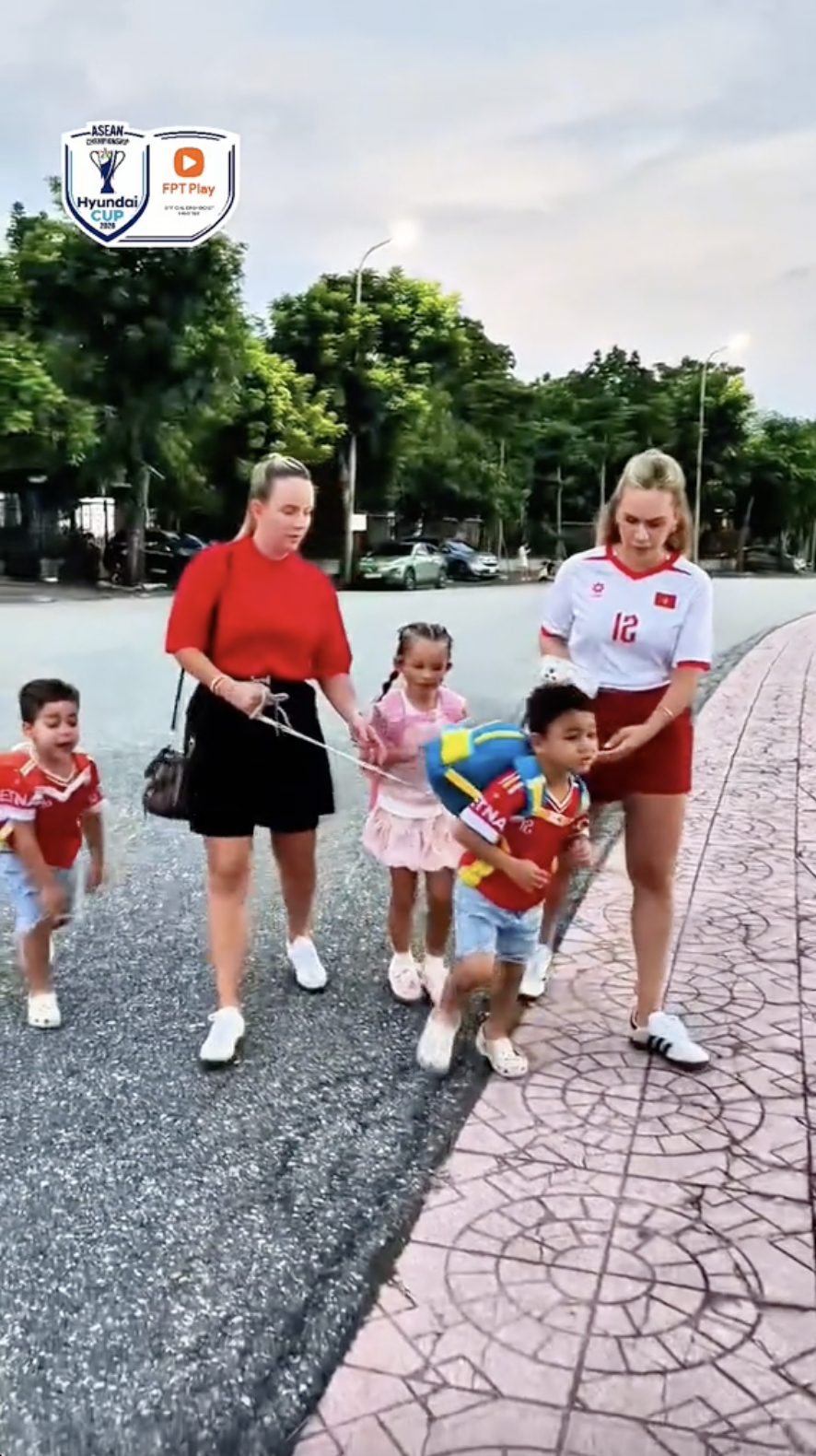 Marcele Seippel (áo trắng) và người thân buộc dây bảo hiểm để dễ dàng dắt con theo (Ảnh cắt từ clip) 