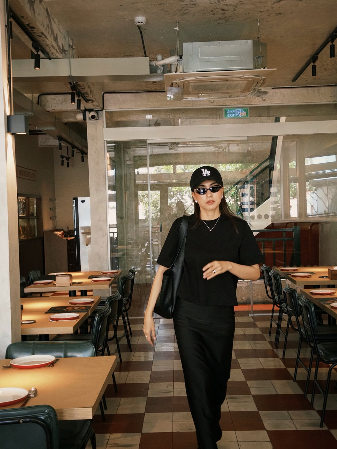 Cứ diện áo phông, Tăng Thanh Hà lại ưu tiên những thiết kế trơn màu và khéo léo phối theo kiểu ton-sur-ton. Với áo phông đen kết hợp cùng chân váy đen dài, cô dễ dàng có ngay một outfit vừa sang vừa sành điệu để xuống phố. Tăng Thanh Hà chọn chân váy ôm nhẹ, tạo phom dáng gọn gàng, đồng thời điểm xuyết những phụ kiện mảnh như khuyên tai, dây chuyền để tổng thể thêm phần tinh tế và nổi bật