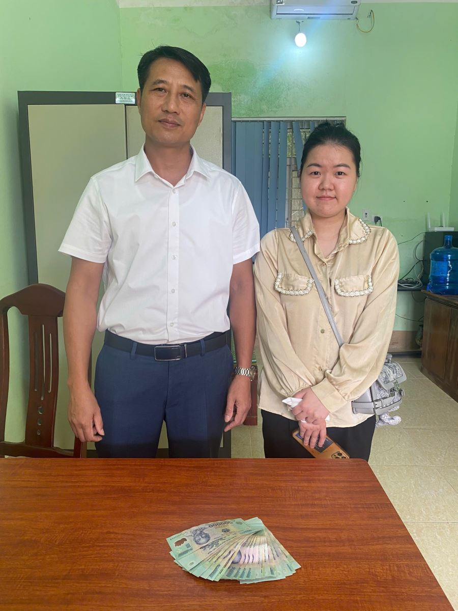 Anh Nguyễn Văn Duy (bên trái) trao trả số tiền 16.500.000 đồng cho chị Trần Thị Phương Thảo tại Công an xã Yên Định. Ảnh: Công an tỉnh Bắc Ninh
