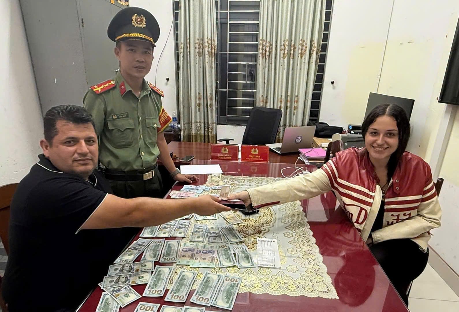 Trước sự chứng kiến của Công an phường Ngũ Hành Sơn, chị Anna trao trả tài sản cho anh Hasan Burser. Ảnh: Công an phường Ngũ Hành Sơn