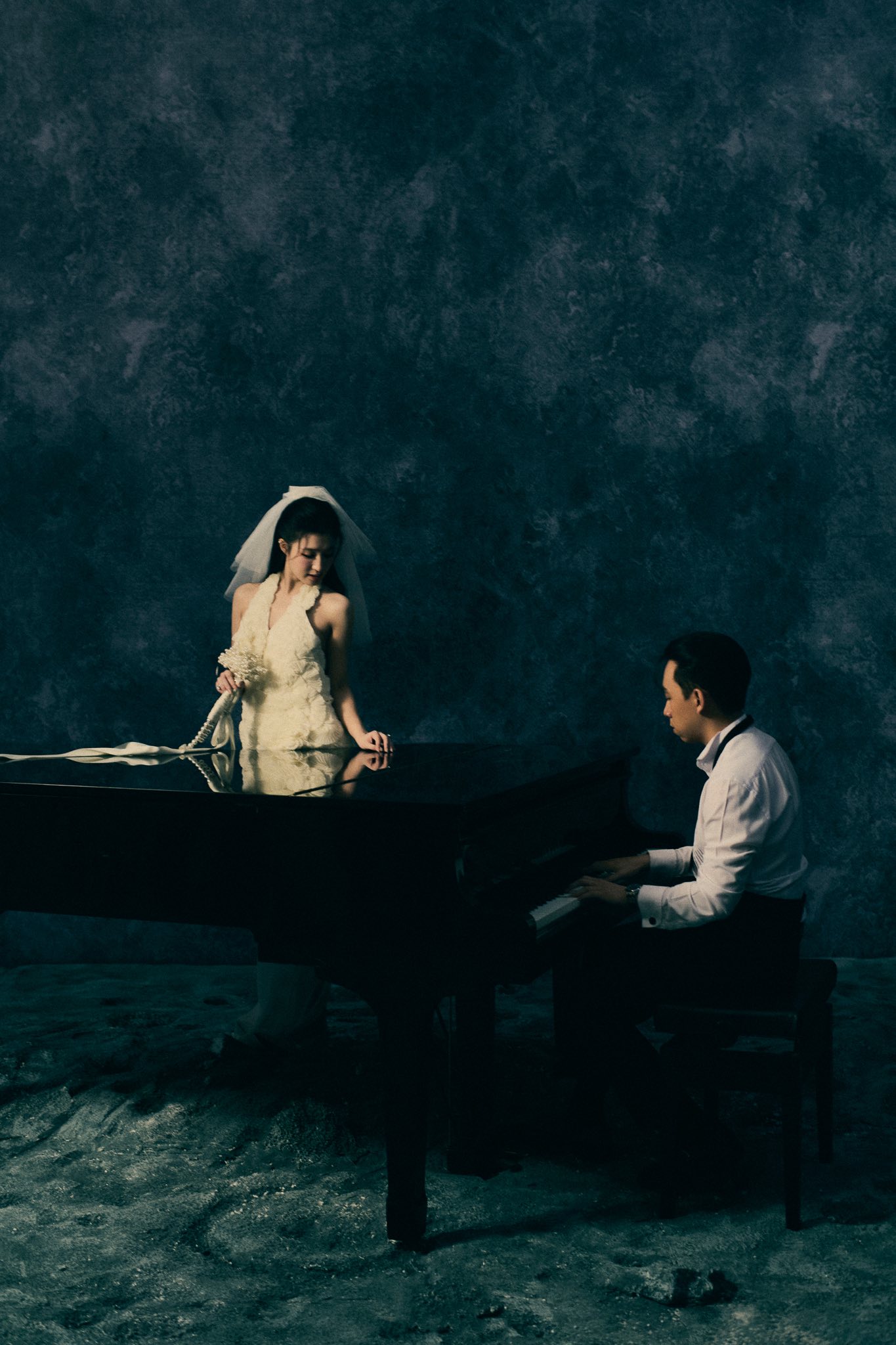 Hai vợ chồng Á hậu tạo dáng bên cây đàn piano.