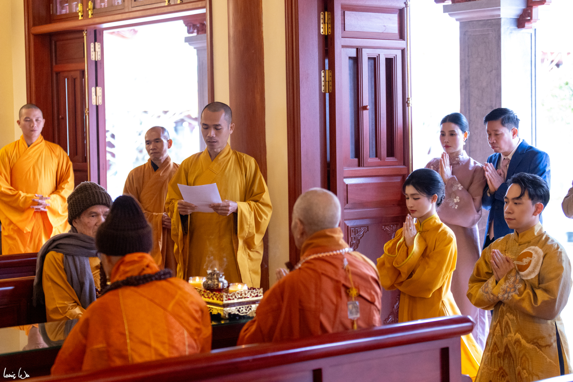 Cặp đôi mặc cổ phục Việt màu vàng đặc trưng của Phật giáo kính cẩn làm lễ hằng thuận ở chùa Trúc Lâm Phụng Thùy Sơn trên núi Chín Khúc (Khánh Hoà), phía sau là bố mẹ cô dâu cùng chứng kiến khoảnh khắc đặc biệt này.