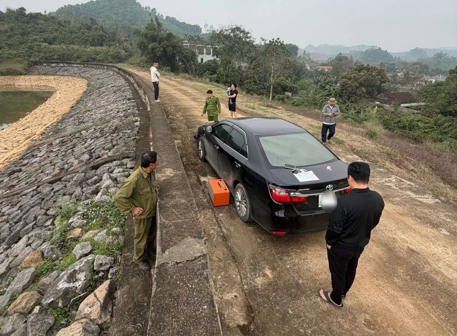 Chiếc ô tô Camry được phát hiện trên bờ hồ Đập Trời, trên thân xe có tờ giấy ghi nội dung tiêu cực. 