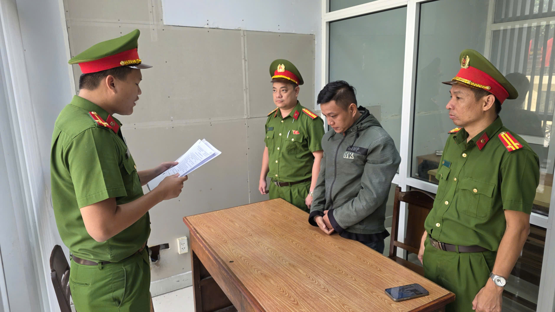 Đại diện cơ quan cảnh sát điều tra đọc lệnh tố tụng đối với Phan Văn Hữu Hà (Ảnh: Công an Đà Nẵng).