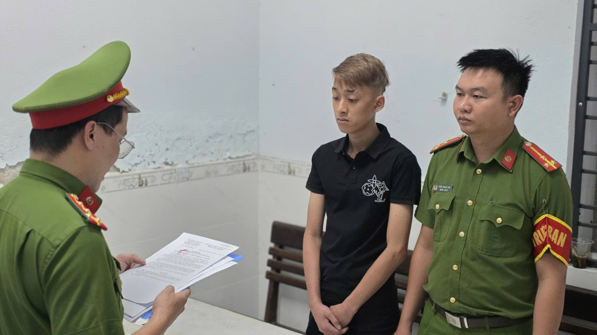 Đại diện cơ quan cảnh sát điều tra đọc lệnh tố tụng đối với Trần Ngọc Quang Khải (Ảnh: Công an Đà Nẵng).