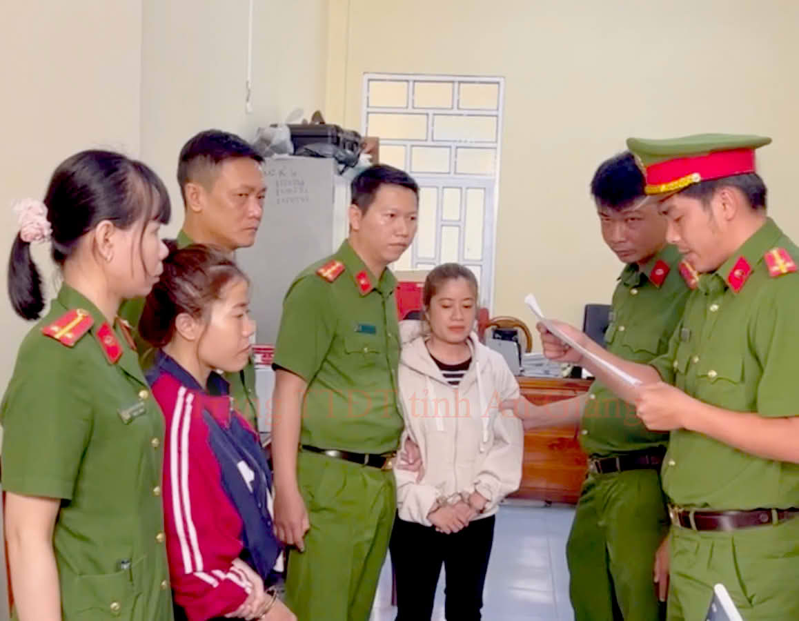 Điều tra viên Cơ quan CSĐT Công an tỉnh thi hành Lệnh bắt bị can để tạm giam đối với Nguyễn Thị Nhung và Trương Thị Rồi (Ảnh: Công an An Giang).