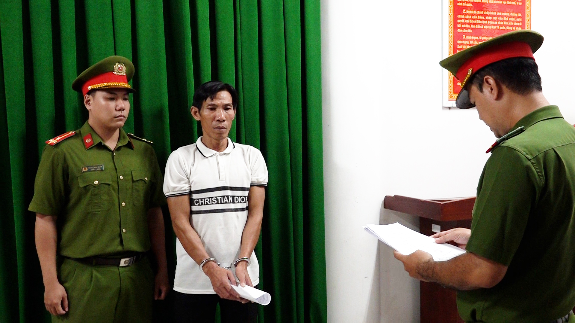 Tống đạt các Quyết định khởi tố vụ án, khởi tố bị can và thi hành lệnh bắt bị can để tạm giam đối với đối tượng Trần Anh Tuấn (Ảnh: Bộ Công an).