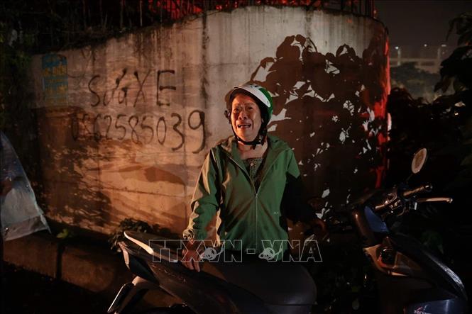 Hình ảnh người phụ nữ lo lắng khi chưa rõ về thông tin của người thân trong vụ cháy. (Ảnh: Phạm Kiên - TTXVN).