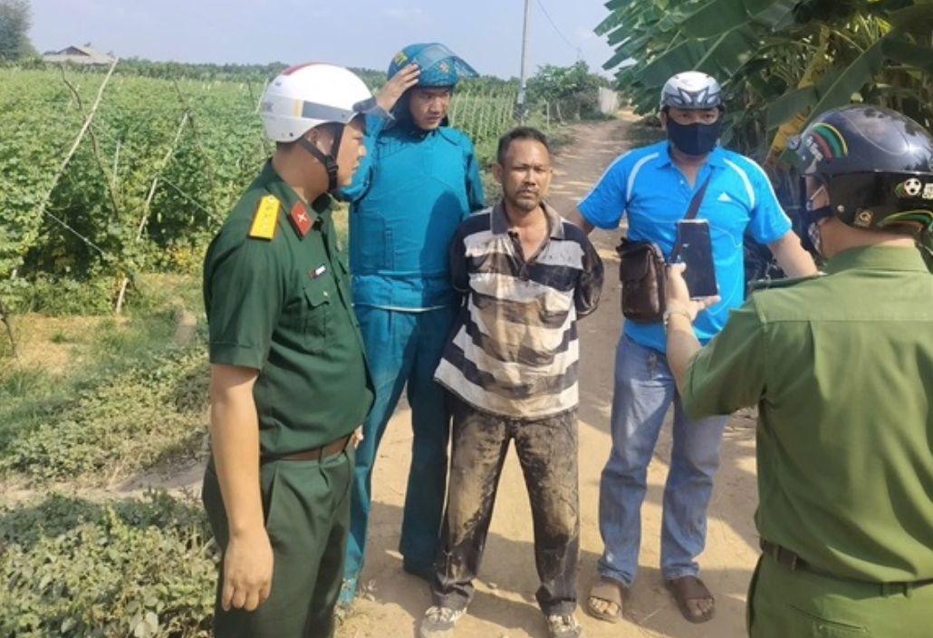 Đối tượng Bình (áo kẻ) bị bắt sau 5 giờ gây án. (Ảnh: Người Lao Động)