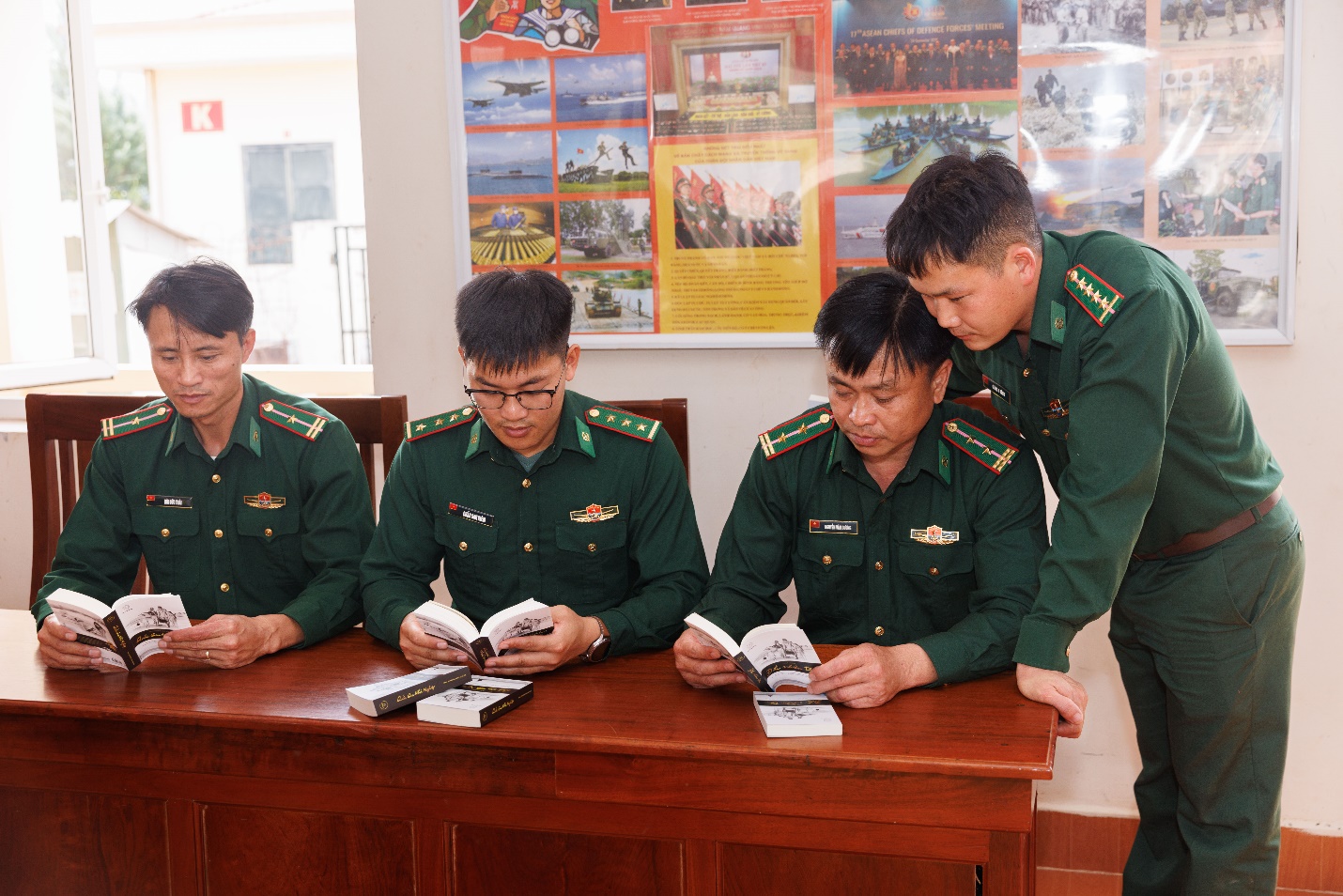 Các chiến sĩ Đồn Biên Phòng Na Cô Sa chăm chú đọc những cuốn sách quý được Hành trình Từ Trái Tim trao tặng