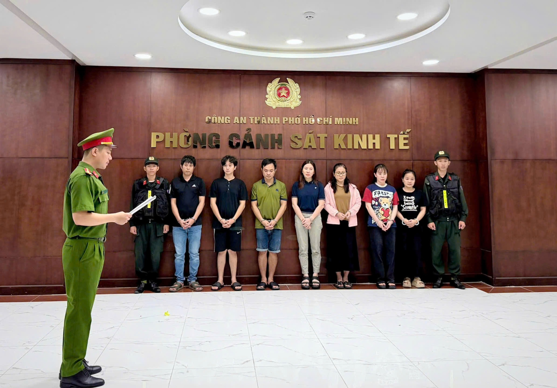 Lê Thị Thùy Trang (áo xanh, giữa) cùng đồng phạm tại Công an TPHCM. Ảnh: Báo NLĐ