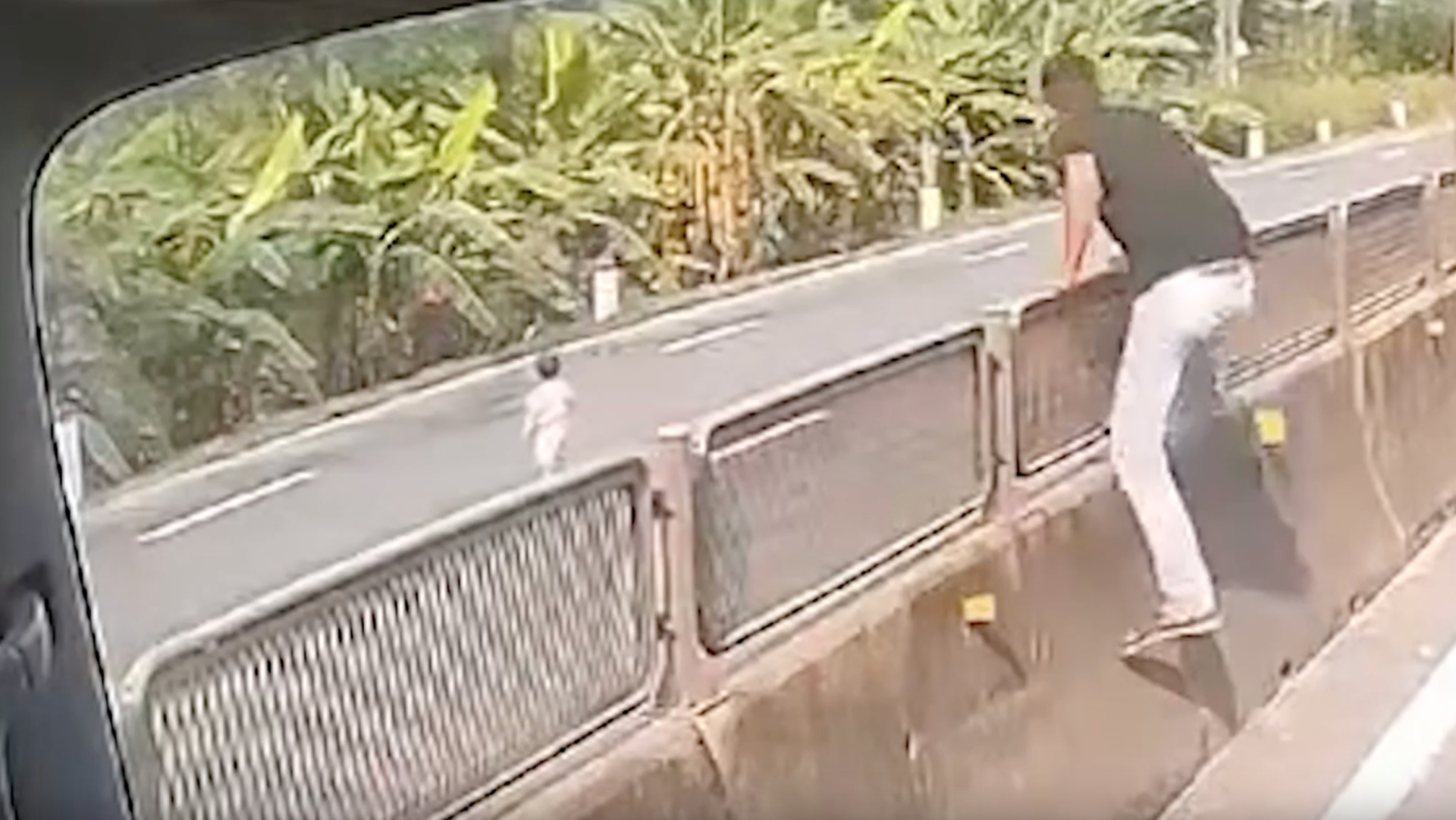 Anh Tố bỏ xe, lao qua dải phân cách cứu cháu bé chạy ra quốc lộ. (Ảnh: Cắt từ clip)