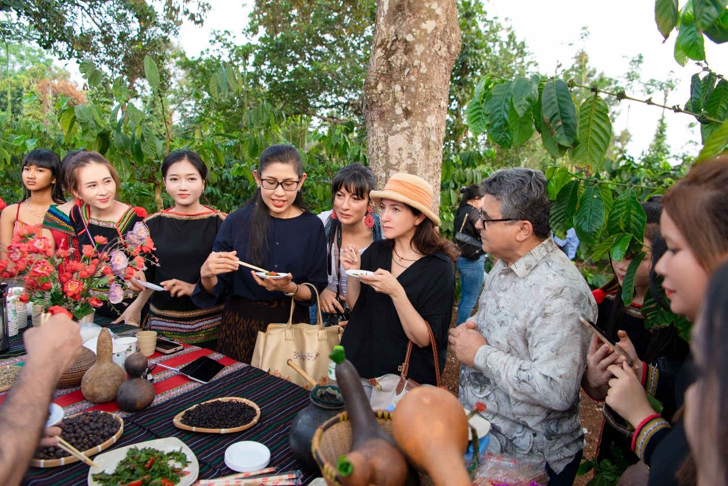   Bà Urawadee Sriphiromya - Đại sứ Vương quốc Thái Lan tại Việt Nam, Bà Camila Polo Florez - Đại sứ Colombia tại Việt Nam, Ông Saadi Salama - Đại sứ Palestine tại Việt Nam (ở giữa từ trái qua) trải nghiệm văn hóa cà phê bản địa trong không gian vườn cà phê ở Buôn Tơng Jú, Đắk Lắk.  