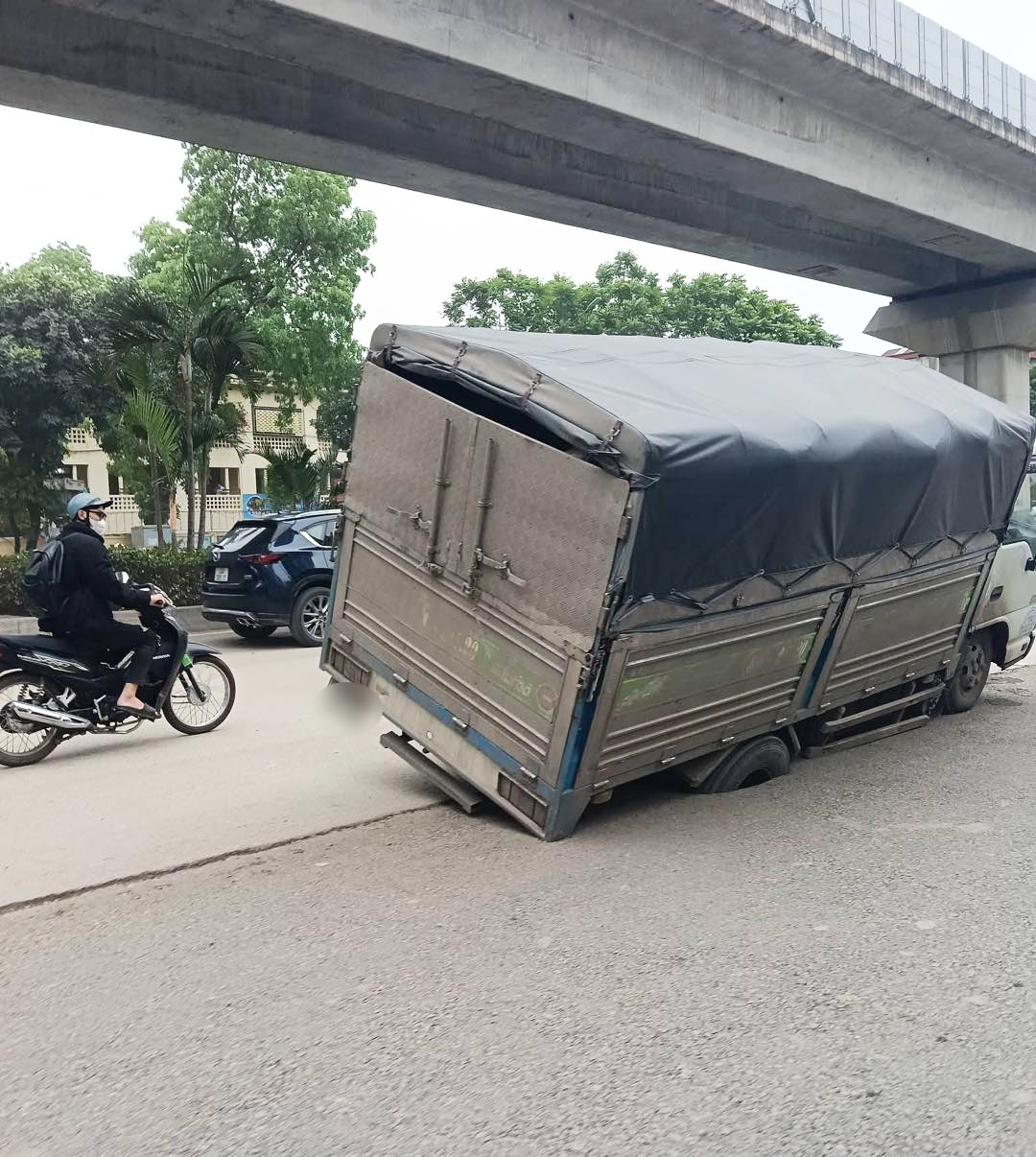 Hình ảnh chiếc xe tải bị sụt bánh, nghiêng hẳn sang một bên trên phố Nguyễn Trãi chiều 23/4. 