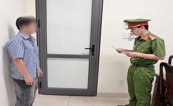 Điều tra viên tống đạt Quyết định khởi tố bị can - Ảnh: Công an Cà Mau