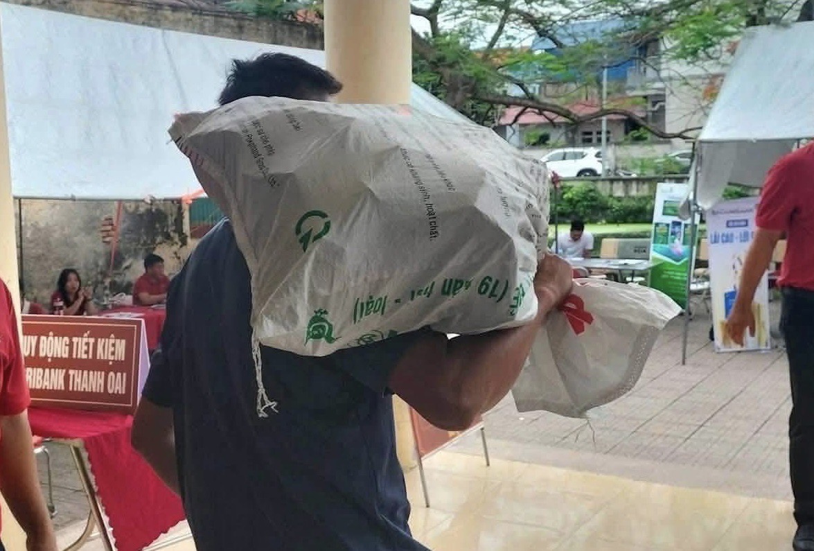 Hình ảnh người dân mang bao tải đi đựng tiền đền bù dự án Khu đô thị thể thao Olympic.