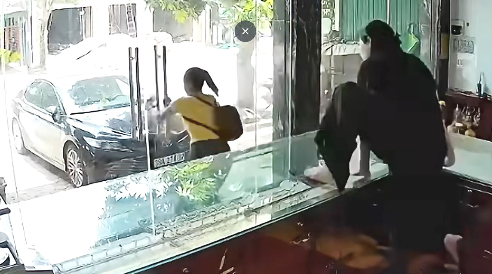 Hình ảnh nữ chủ tiệm vàng nhảy qua tủ kính nhưng vẫn không bắt được người đàn bà cướp vàng (Ảnh: Công an nhân dân).