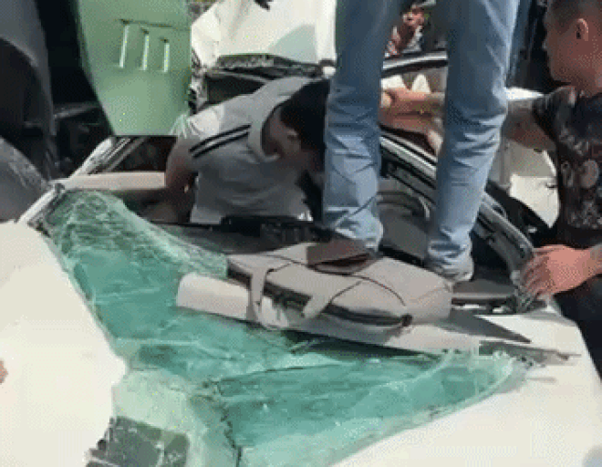 Lực lượng chức năng cùng người dân hỗ trợ đưa tài xế ra ngoài. 