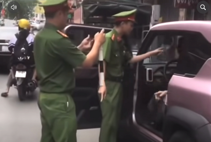 Nữ tài xế cố thủ trong xe, lớn tiếng với cảnh sát. (Ảnh: Cắt từ clip)