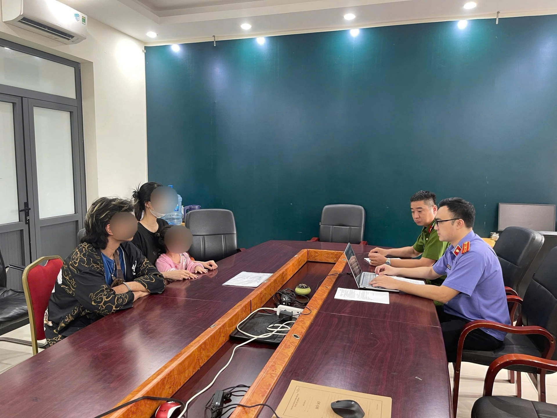 Công an phường Đống Đa và Viện Kiểm sát nhân dân khu vực 2 Thành phố Hà Nội làm việc cùng gia đình cháu bé. (Nguồn: Công an Hà Nội)
