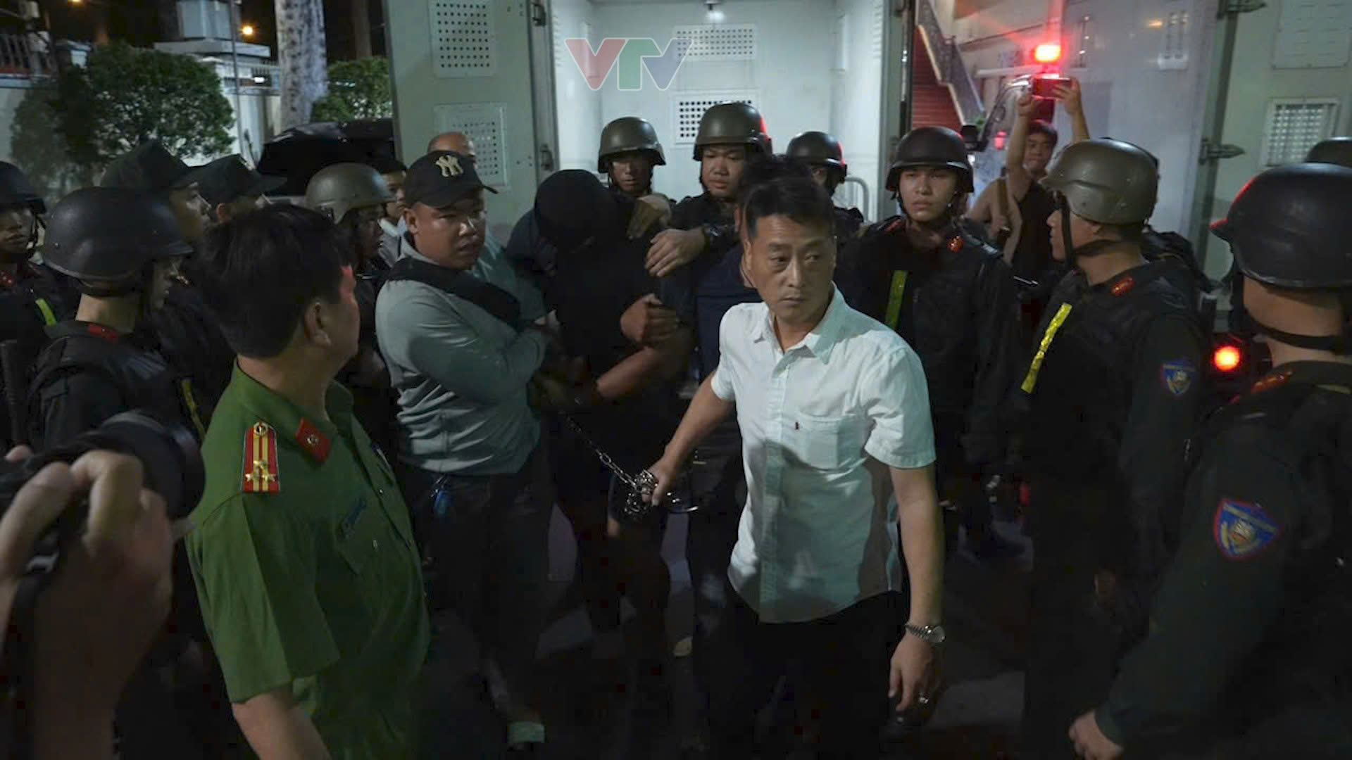 Công an bắt 2 nghi phạm - Ảnh: VTV9
