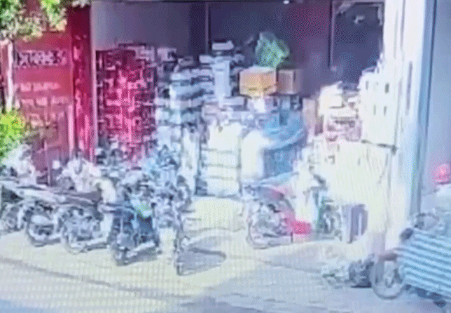 Camera ghi lại cảnh người đàn ông tạt chất lỏng vào tiệm, sau đó lửa bốc lên. (Ảnh: Cắt từ clip)