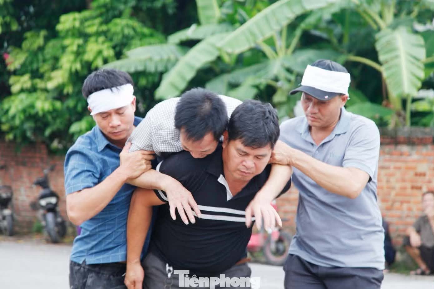 Bố của chị N. ngã quỵ trên đường đưa tiễn con cháu về nơi an nghỉ cuối cùng. (Ảnh: Tiền Phong).