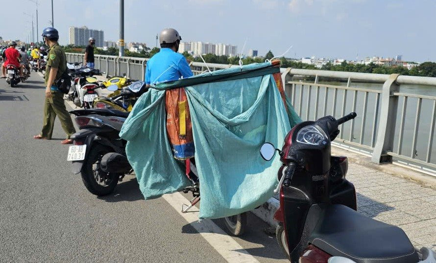 Hiện trường nơi nam thanh niên để lại xe máy và thùng hàng, nhảy cầu mất tích. (Ảnh: Công Lý)