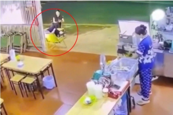 Thời điểm xảy ra vụ việc, ông H. đang ngồi trò chuyện với một phụ nữ ở trước quán nước. (Ảnh cắt từ clip)