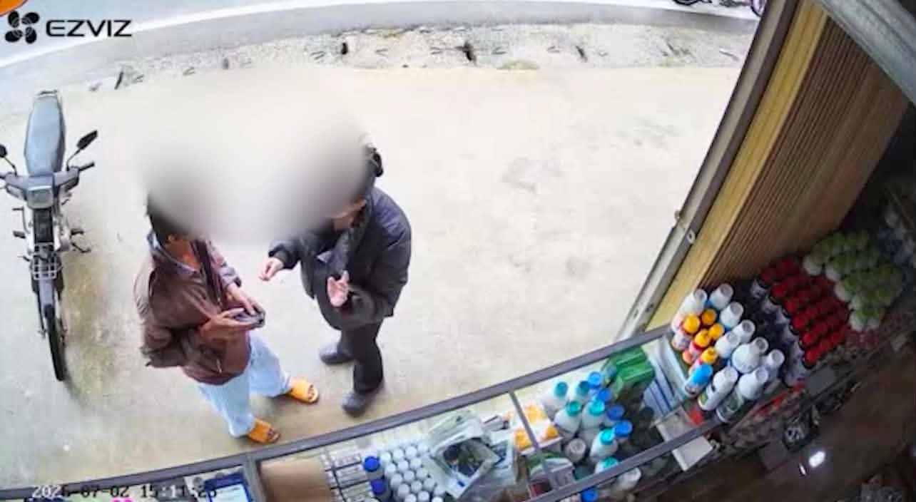 Nữ nhân viên kiên quyết không bán chai thuốc trừ sâu cho người đàn ông. (Ảnh: Cắt từ clip)