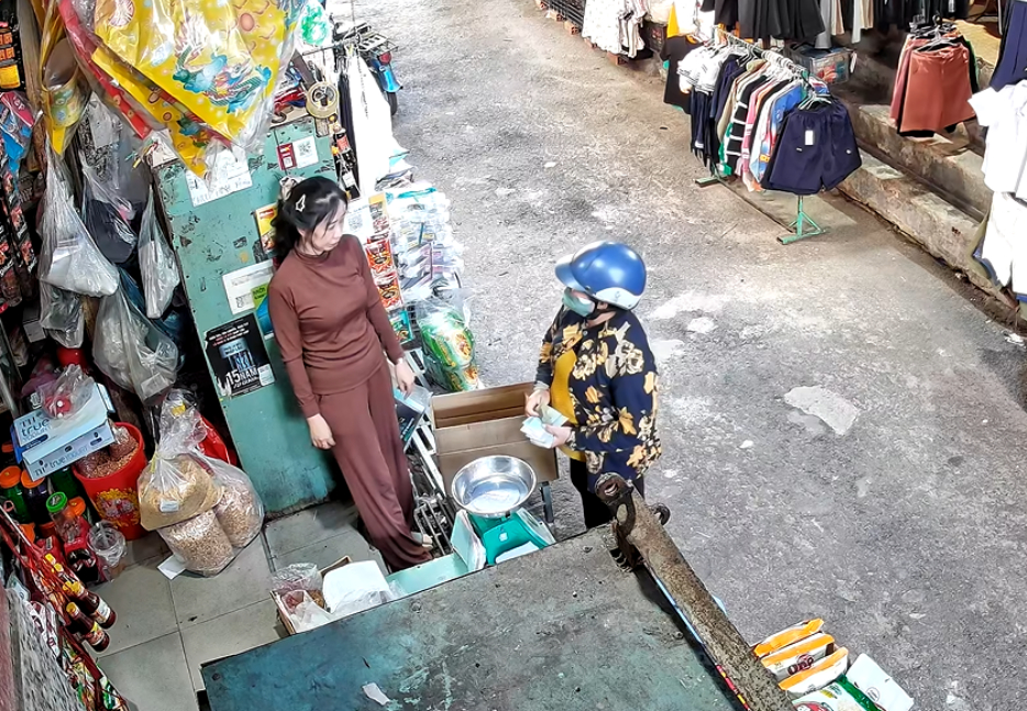 Người phụ nữ (đội mũ bảo hiểm) đến trả món nợ cũ và sững sờ khi biết chủ nợ đã qua đời. (Ảnh: Cắt từ clip)