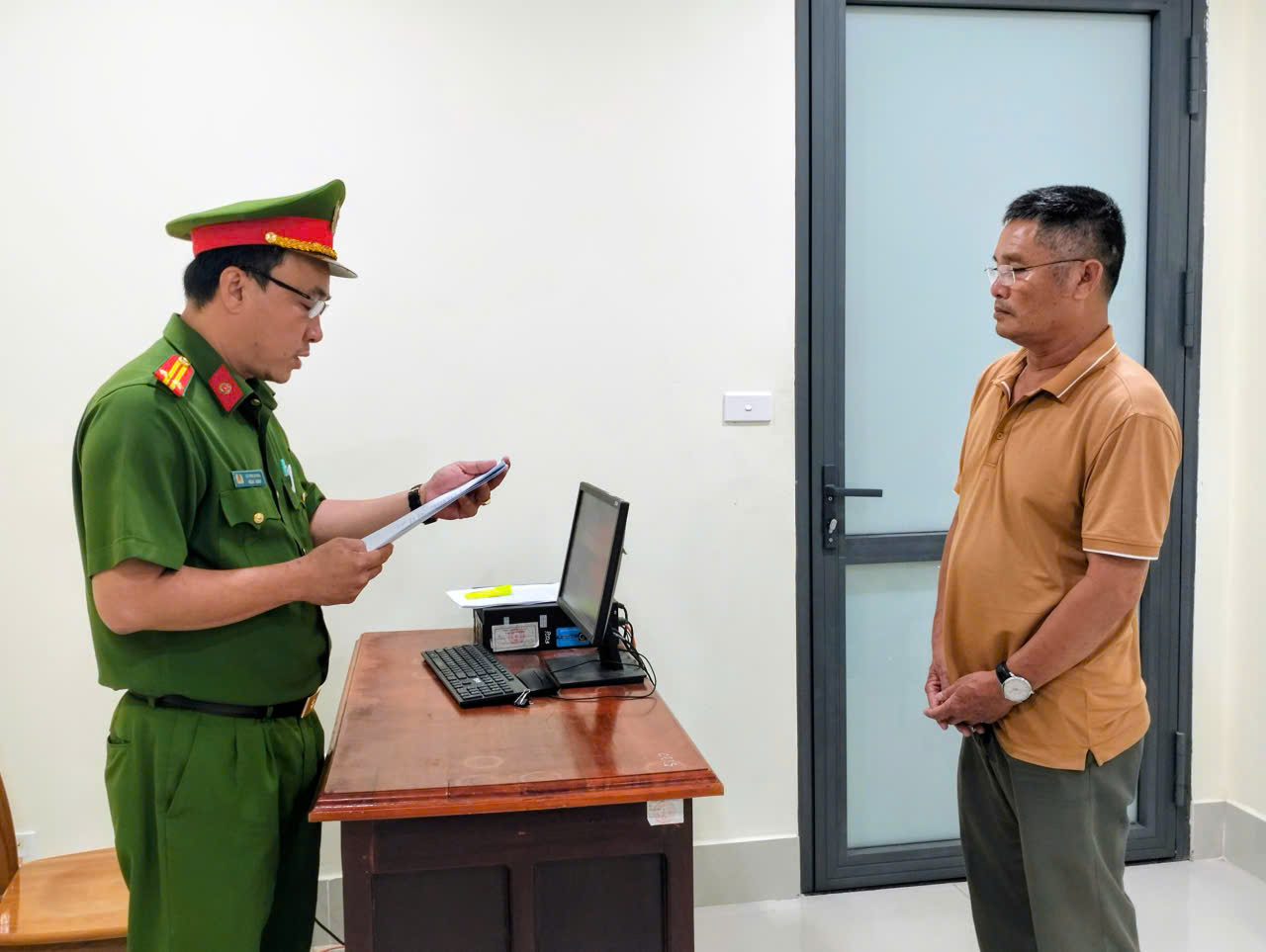 Cơ quan điều tra tống đạt quyết định khởi tố bị can Hoàng Văn Dương - Ảnh: Công an An Giang
